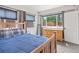 Bright bedroom featuring a wooden bed, large window overlooking backyard, and gray carpet at 3241 Sheridan Blvd, Wheat Ridge, CO 80212