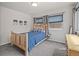 Carpeted bedroom with a wood bed frame, mountain art, and natural light at 3241 Sheridan Blvd, Wheat Ridge, CO 80212