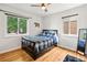 Bedroom with hardwood floors, two windows, ceiling fan, and cozy decor at 3241 Sheridan Blvd, Wheat Ridge, CO 80212