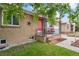 Charming brick home featuring a pink front door and inviting porch area at 3241 Sheridan Blvd, Wheat Ridge, CO 80212
