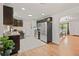 Eat-in kitchen features stainless steel appliances, dark cabinets, and views into the dining room at 3241 Sheridan Blvd, Wheat Ridge, CO 80212