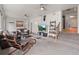 Cozy living room boasts plush seating, a ceiling fan, and decorative shelves on the staircase at 3241 Sheridan Blvd, Wheat Ridge, CO 80212