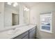 Bathroom with a dual sink vanity, modern fixtures, and a view from the window at 3226 Belleville Ridge Rd, Elizabeth, CO 80107