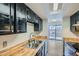 A kitchen with wood countertops, stainless steel sink and black cabinets at 8643 Carr Loop, Westminster, CO 80005