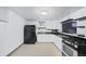 Basement kitchen features black appliances and countertops with white cabinets and beige flooring at 3131 S Washington St, Englewood, CO 80113