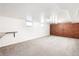 Spacious living area with carpeted flooring, a brick wall, and a small black countertop bar at 3131 S Washington St, Englewood, CO 80113