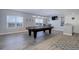 Finished basement featuring a pool table, bar, windows, modern lighting, and gray wood-look floors at 24963 E Phillips Pl, Aurora, CO 80016