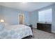 Comfortable bedroom with blue walls, a bed with patterned linens, and a dresser with carpeted floors at 24963 E Phillips Pl, Aurora, CO 80016