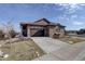 Beautiful home featuring stone accents, a two-car garage, and a well-manicured lawn at 24963 E Phillips Pl, Aurora, CO 80016