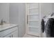 Bright laundry room with front loading washer and dryer, utility sink, white shaker cabinets, and white door at 24963 E Phillips Pl, Aurora, CO 80016