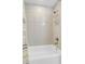 Modern tub/shower with white tiles, silver fixtures, and shower caddy at 1585 Hecla Way # 304, Louisville, CO 80027