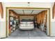 View of the home's well-organized garage with wood siding, storage shelves, and a rear-facing parked car at 1585 Hecla Way # 304, Louisville, CO 80027