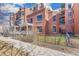 Brick condo building featuring a fenced front yard and a sidewalk leading up to the front entrance at 410 Acoma St # Brownstone 3, Denver, CO 80204