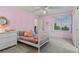 Charming bedroom features a single bed, pink walls, and a window with natural light at 27290 E Nova Cir, Aurora, CO 80016
