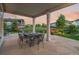 Covered patio with stone flooring provides a relaxing outdoor dining area with a view of the landscaped backyard at 27290 E Nova Cir, Aurora, CO 80016