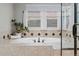 Bright main bathroom features a large tub with tile accents, a window view, and a glass shower at 27290 E Nova Cir, Aurora, CO 80016