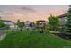 Fenced backyard with a wooden playground and lush green grass is great for outdoor activities at 27290 E Nova Cir, Aurora, CO 80016