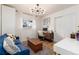 Home office with blue sofa, desk, and ample natural light at 1946 Rosemary St, Denver, CO 80220