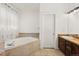 Bathroom with a soaking tub, wood cabinets, light walls and tiled flooring at 2080 S Danube Ct, Aurora, CO 80013
