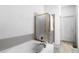 Bathroom features a bathtub with a glass shower enclosure and a door leading to the hallway at 9567 Brentwood Way # A, Broomfield, CO 80021