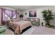 Comfortable bedroom with decorative pillows, adjacent sitting area and a painting at 9567 Brentwood Way # A, Broomfield, CO 80021