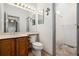 Bathroom featuring vanity sink, toilet, and walk-in shower with white shower curtain at 6544 Alkire Ct, Arvada, CO 80004