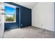 Modern bedroom featuring blue accent wall and a window with exterior views at 6544 Alkire Ct, Arvada, CO 80004