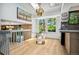 Dining area with modern chandelier, backyard views, and stainless steel shelving at 6544 Alkire Ct, Arvada, CO 80004