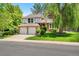 Charming two-story home featuring a well-manicured lawn, a mature weeping willow, and a convenient two-car garage at 6544 Alkire Ct, Arvada, CO 80004