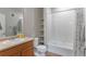 Well-lit bathroom with single sink vanity, toilet, and combined shower and tub at 14341 E Tennessee Ave # 203, Aurora, CO 80012