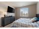 Inviting bedroom featuring a mounted TV, dresser, and a well-lit window for natural light at 14341 E Tennessee Ave # 203, Aurora, CO 80012