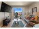 Cozy living room with a large sliding glass door, a comfortable leather sofa, and a flat-screen TV at 14341 E Tennessee Ave # 203, Aurora, CO 80012