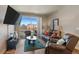 Comfortable living room with balcony, flat-screen TV, leather seating, and lots of natural light at 14341 E Tennessee Ave # 203, Aurora, CO 80012