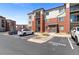 Exterior view of the building showcasing parking spaces and well-manicured landscaping at 14341 E Tennessee Ave # 203, Aurora, CO 80012
