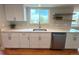 Well-lit kitchen featuring white cabinets, stainless steel appliances, and hardwood floors at 18073 E Belleview Pl, Centennial, CO 80015
