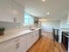 Bright kitchen with white cabinets, stainless steel appliances, and wooden shelves at 18073 E Belleview Pl, Centennial, CO 80015