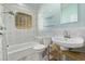 Bathroom featuring a tub, shower and sink with sleek fixtures and a glass block window at 1601 Jackson St, Denver, CO 80206