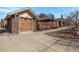 Brick house and garage with a concrete driveway and manicured yard with wood fencing and nice landscaping at 1601 Jackson St, Denver, CO 80206