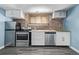 Kitchen featuring stainless steel appliances, brick wall and gray wood-like floor at 1601 Jackson St, Denver, CO 80206