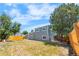 Backyard view of the gray two-story home with mature trees and wood fencing at 1705 Cathay Ct, Aurora, CO 80011