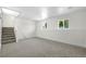 Basement featuring neutral carpet, staircase, and windows with natural light at 1705 Cathay Ct, Aurora, CO 80011