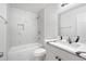 Bathroom with marble-style walls, bathtub, shower, and vanity with sink at 1705 Cathay Ct, Aurora, CO 80011