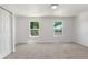 Bright and airy bedroom with neutral carpet, two windows, and a closet at 1705 Cathay Ct, Aurora, CO 80011