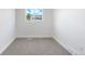 Bright bedroom featuring neutral carpet, crisp white trim, and a window view at 1705 Cathay Ct, Aurora, CO 80011