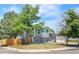 Landscaped two-story home with gray siding and white trim plus a two-car garage and lush mature trees at 1705 Cathay Ct, Aurora, CO 80011