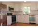 Bright kitchen with stainless appliances, white cabinets, and a window view at 1705 Cathay Ct, Aurora, CO 80011