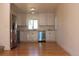 Open kitchen area with stainless steel appliances, white cabinets, and hardwood floors at 1705 Cathay Ct, Aurora, CO 80011
