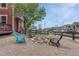 Backyard with rock fire pit, surrounded by chairs in a fenced in area with tree, sky, and other homes at 22965 Allendale Ave, Parker, CO 80138