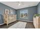 Blue Bedroom with white crib, dresser and large window at 22965 Allendale Ave, Parker, CO 80138
