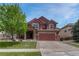 Charming two-story home with a well-manicured lawn and beautiful mature tree providing shade at 22965 Allendale Ave, Parker, CO 80138
